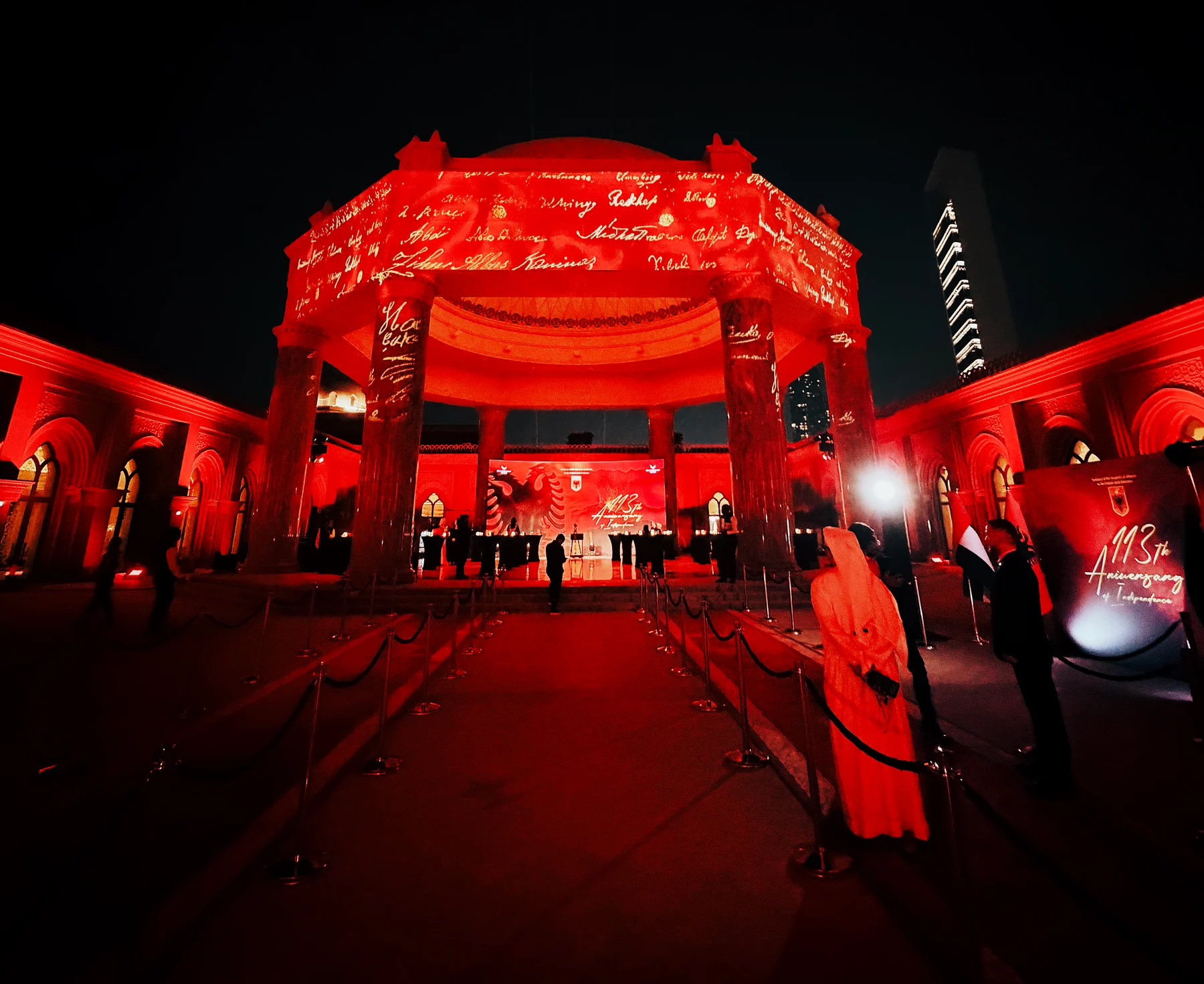 Red Independence Day projection surrounds guests at a colonnaded event pavilion at Emirates Palace Mandarin Oriental in Abu Dhabi